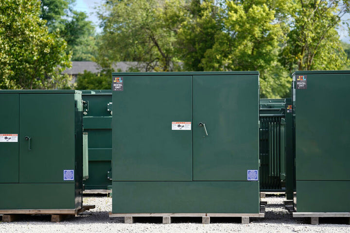Green metal storage containers with trees in the background