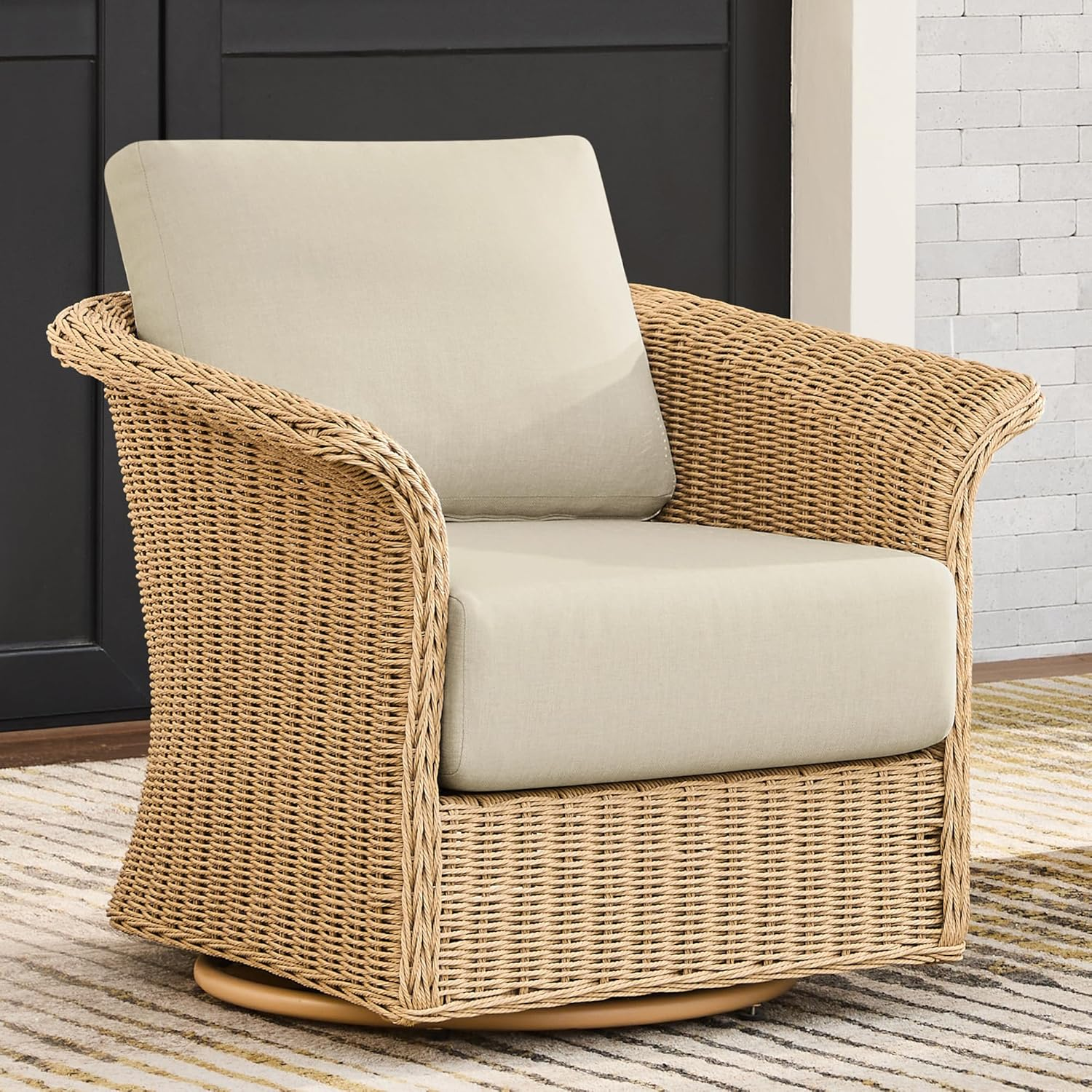 Wicker armchair with beige cushions on a striped rug