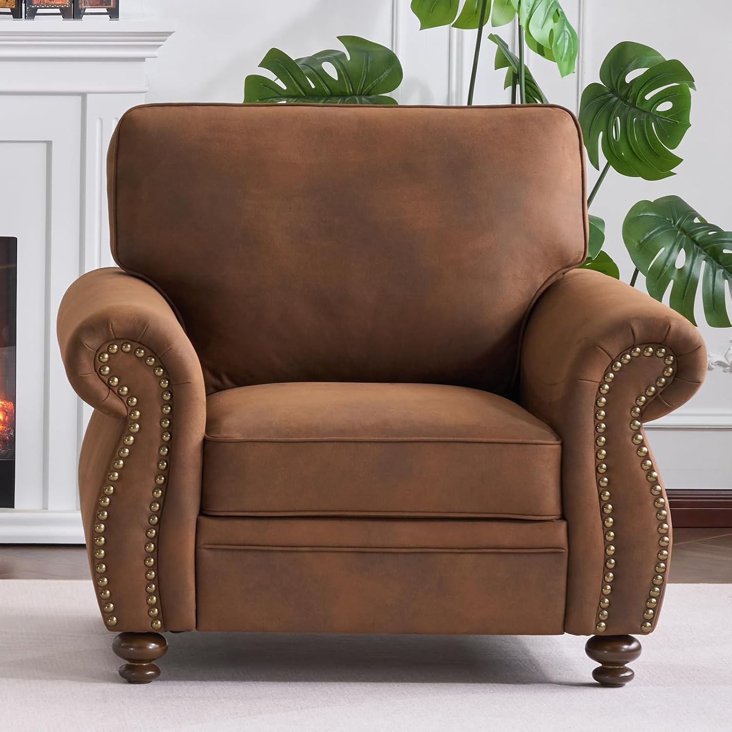 Brown leather armchair with nailhead trim in a room with plants and a fireplace.