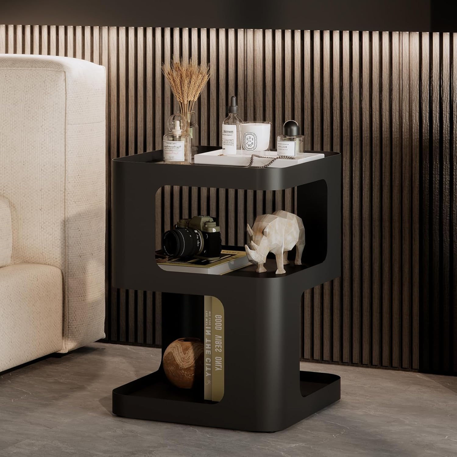 Black side table with decorative items in a modern living room setting