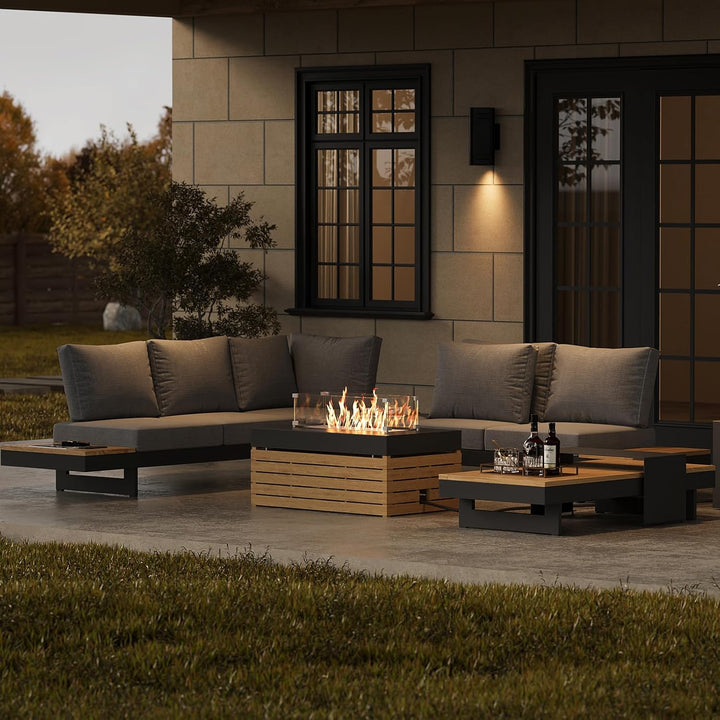 Outdoor patio setting with a fire pit table and seating area at dusk.