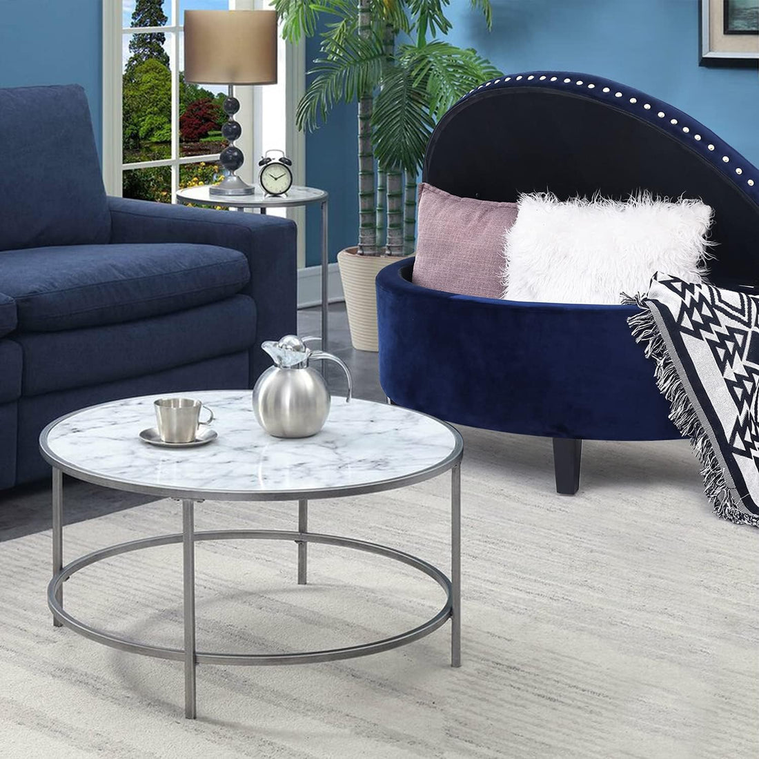 Living room with navy blue sofa, round coffee table, and decorative items.