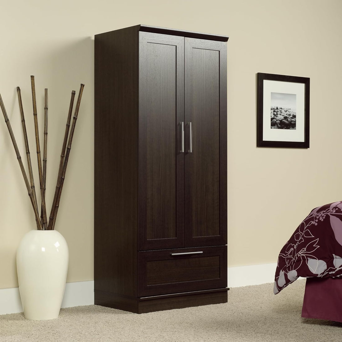 Dark wood wardrobe with a white vase and decorative plant in a room.