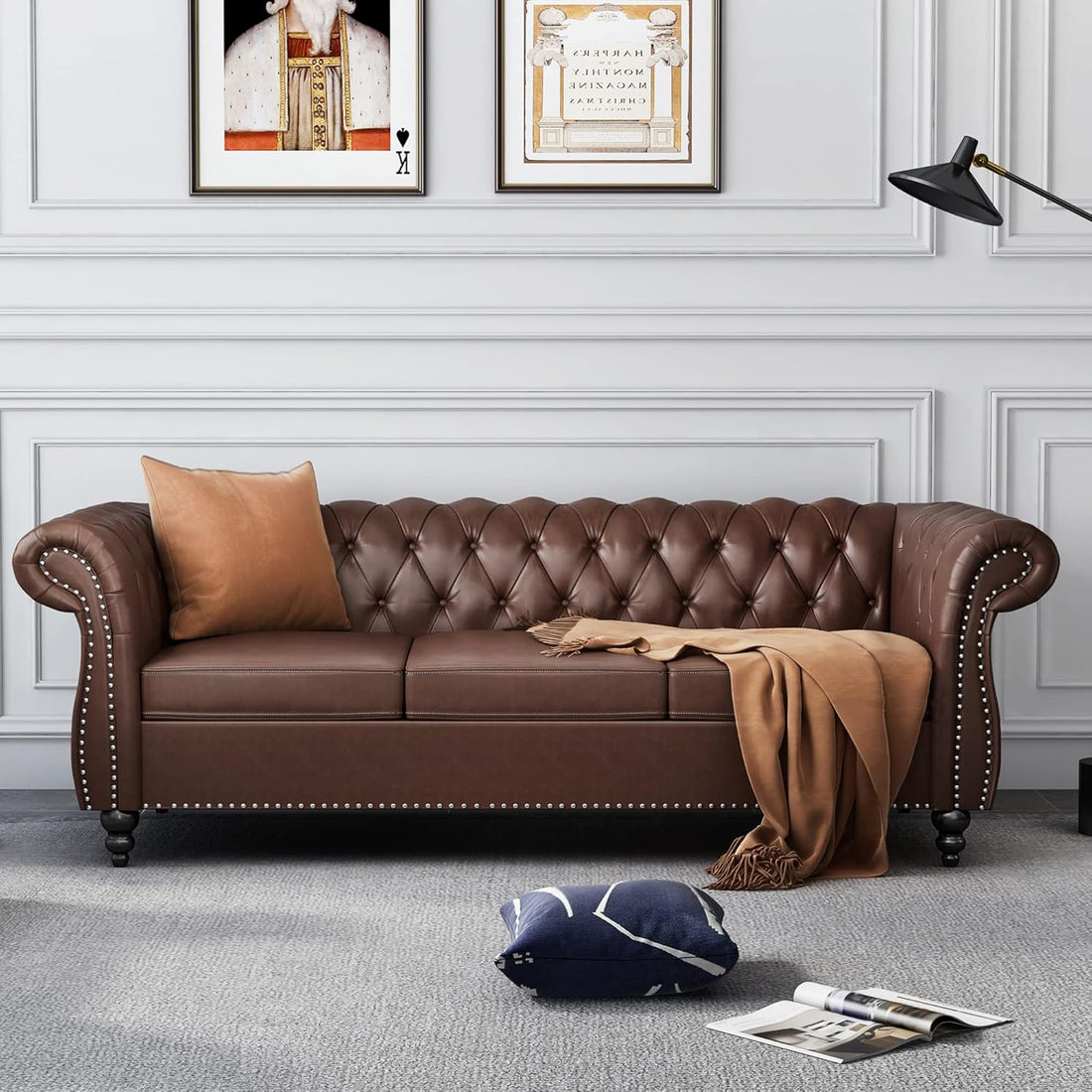 Brown leather sofa in a living room with decorative pillows and a blanket.