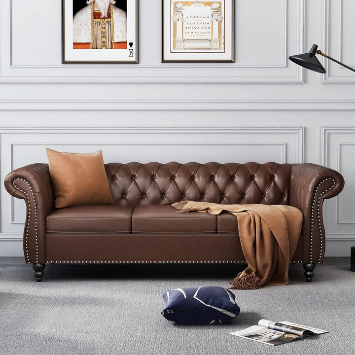 Brown leather sofa in a living room with decorative pillows and a blanket.