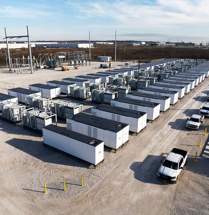 Row of white modular buildings in a storage yard with a truck parked nearby.