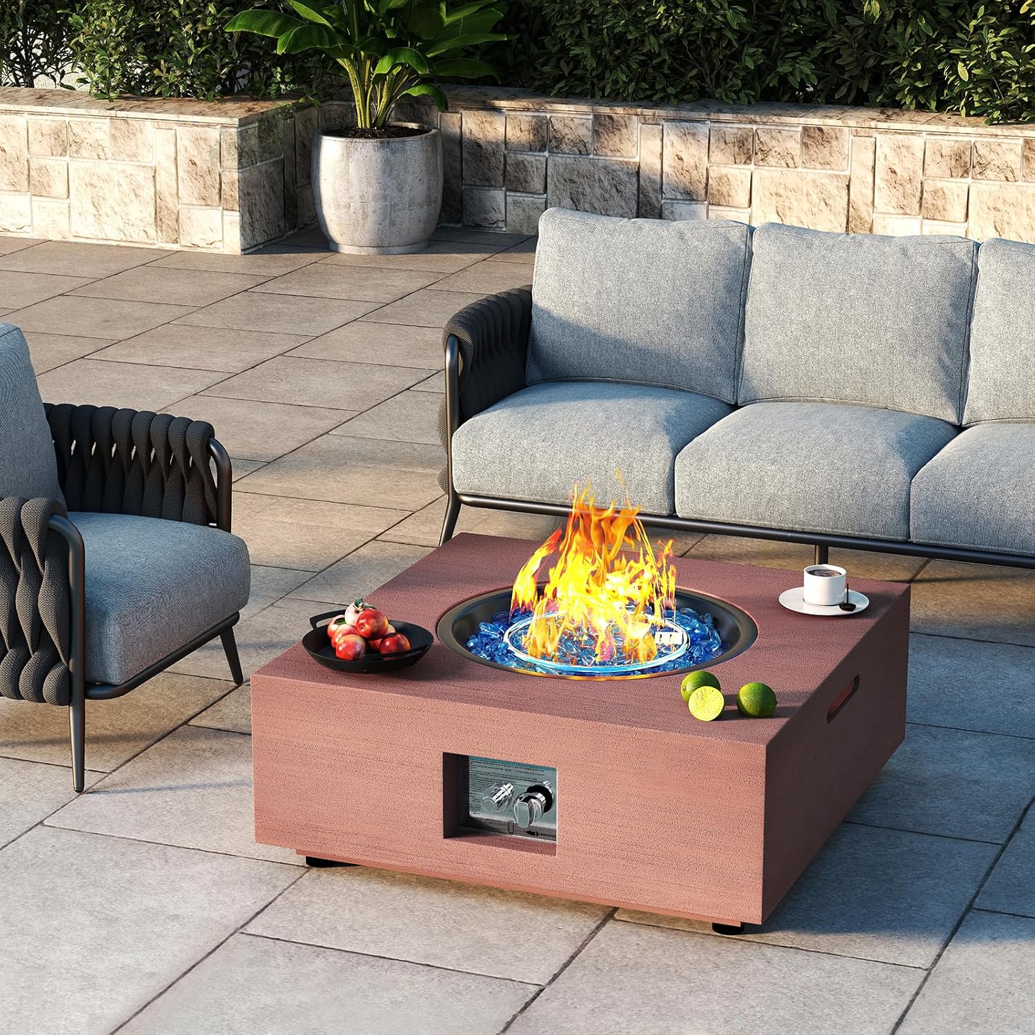 Outdoor patio setting with a fire pit table, gray sofa, and armchair.
