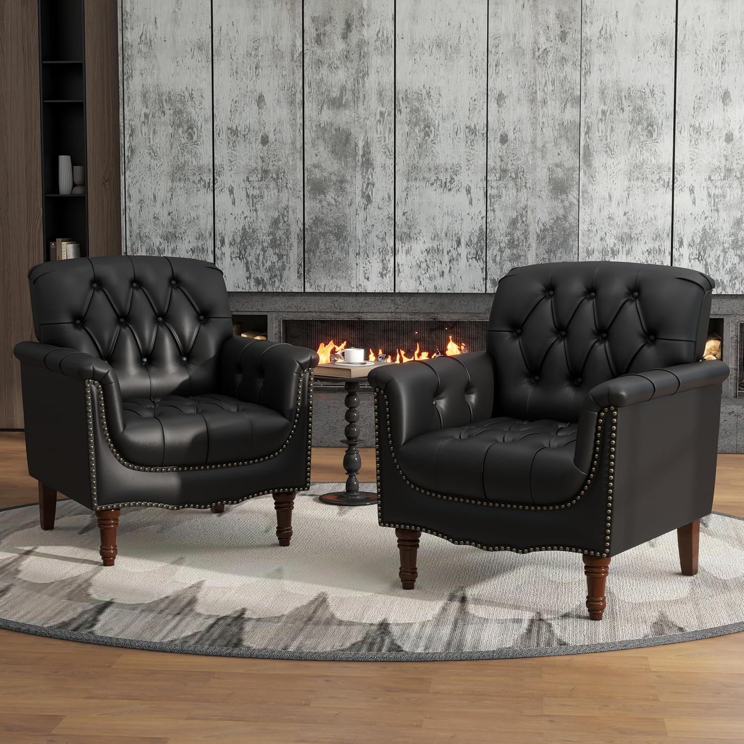 Two black leather armchairs in front of a fireplace with a wooden floor and rug.