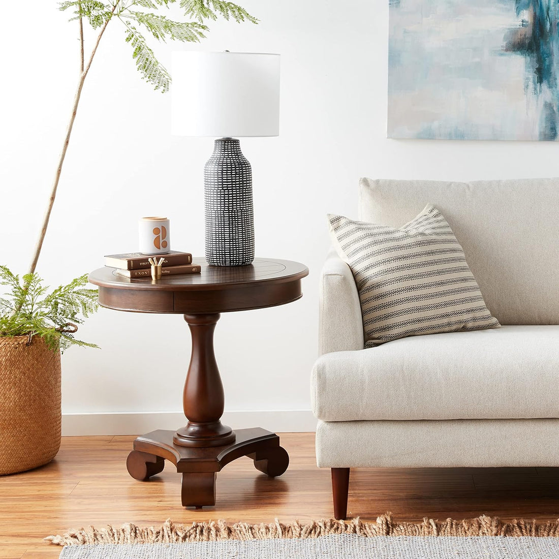 Living room with a wooden side table, lamp, and beige sofa with a striped pillow.