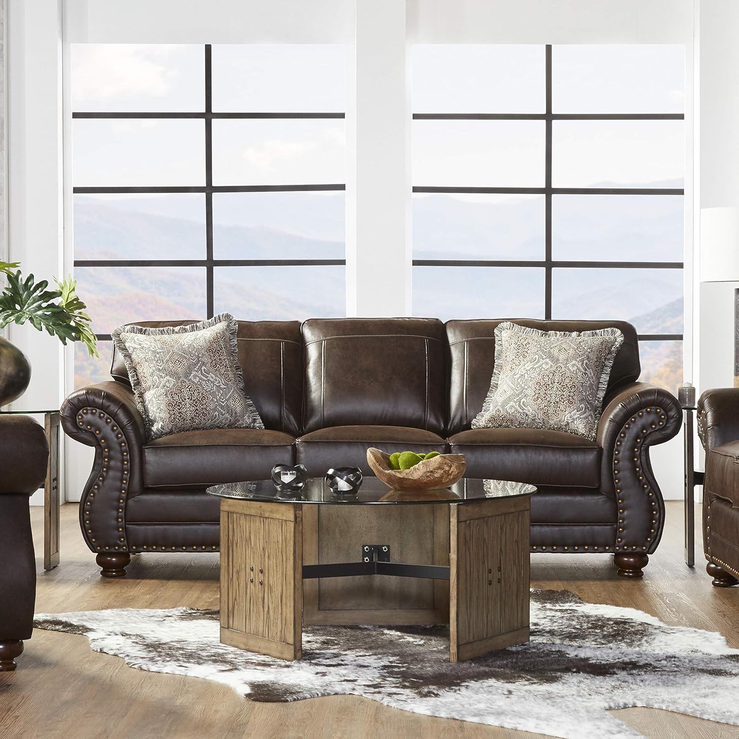 Brown leather sofa with decorative pillows in a modern living room setting.