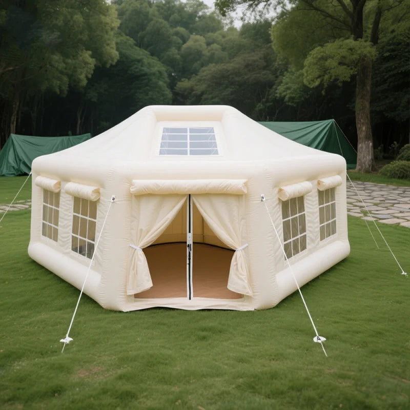 Inflatable tent with solar panel on top in a grassy area with trees in the background