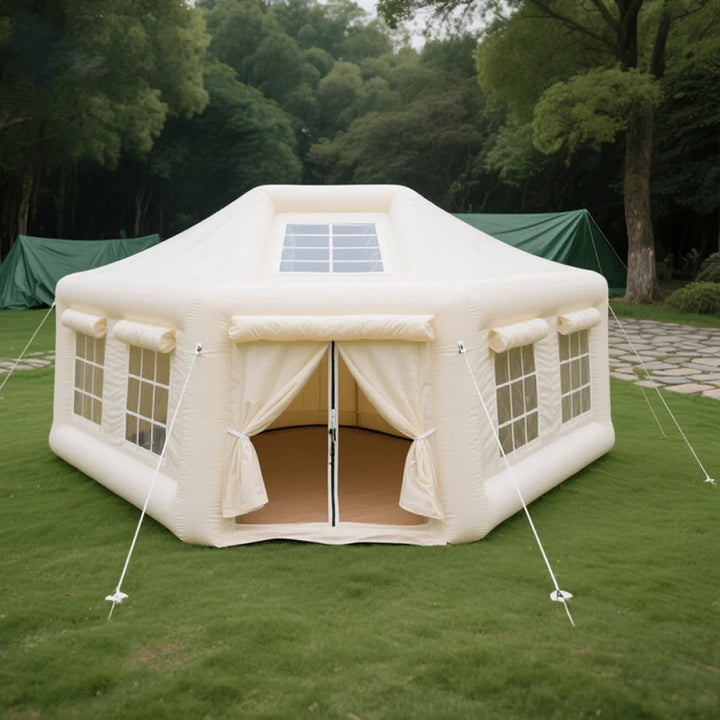 Inflatable tent with solar panel on top in a grassy area with trees in the background
