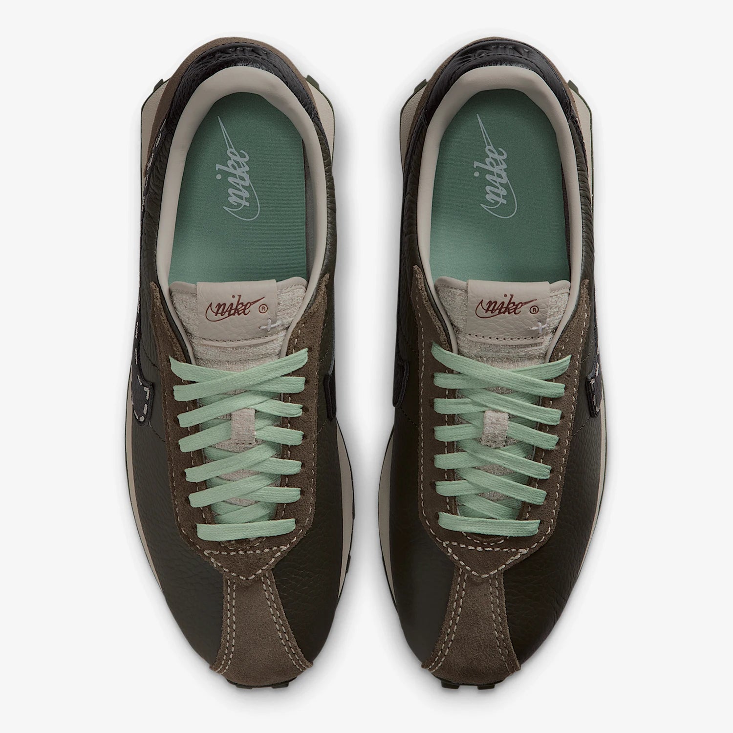 Pair of brown sneakers with green laces on a white background