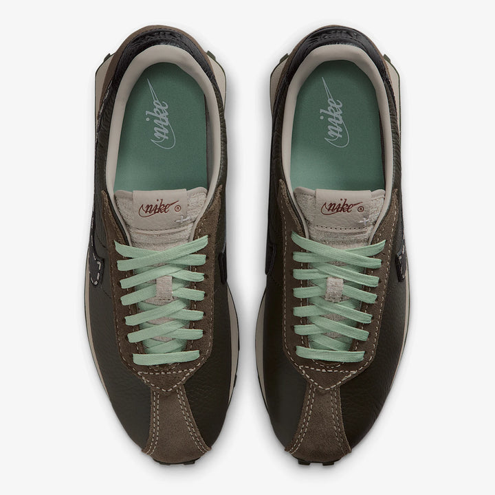 Pair of brown sneakers with green laces on a white background