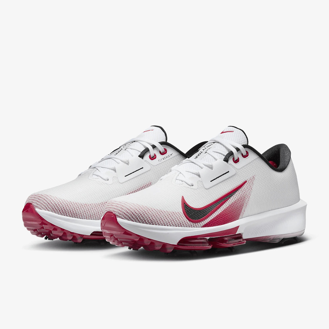 A pair of Nike golf shoes in white with a dark red and green gradient Swoosh, pinkish-red cleats, and black accents, shown on a light gray background.