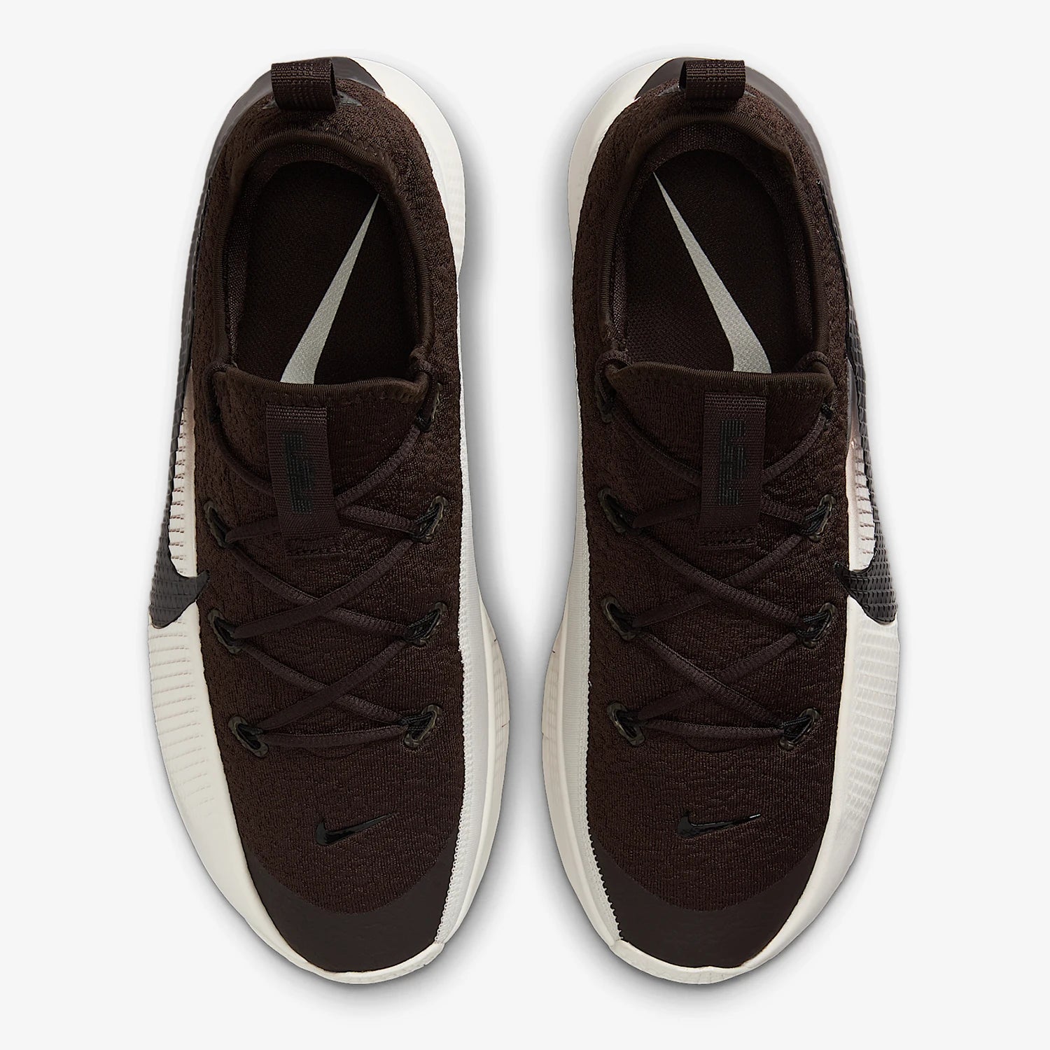 A pair of Nike sneakers shown from a top-down view. The shoes feature a dark brown textured knit upper, black laces, black Swoosh logos, and a thick white midsole.