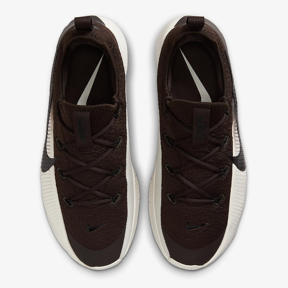 A pair of Nike sneakers shown from a top-down view. The shoes feature a dark brown textured knit upper, black laces, black Swoosh logos, and a thick white midsole.