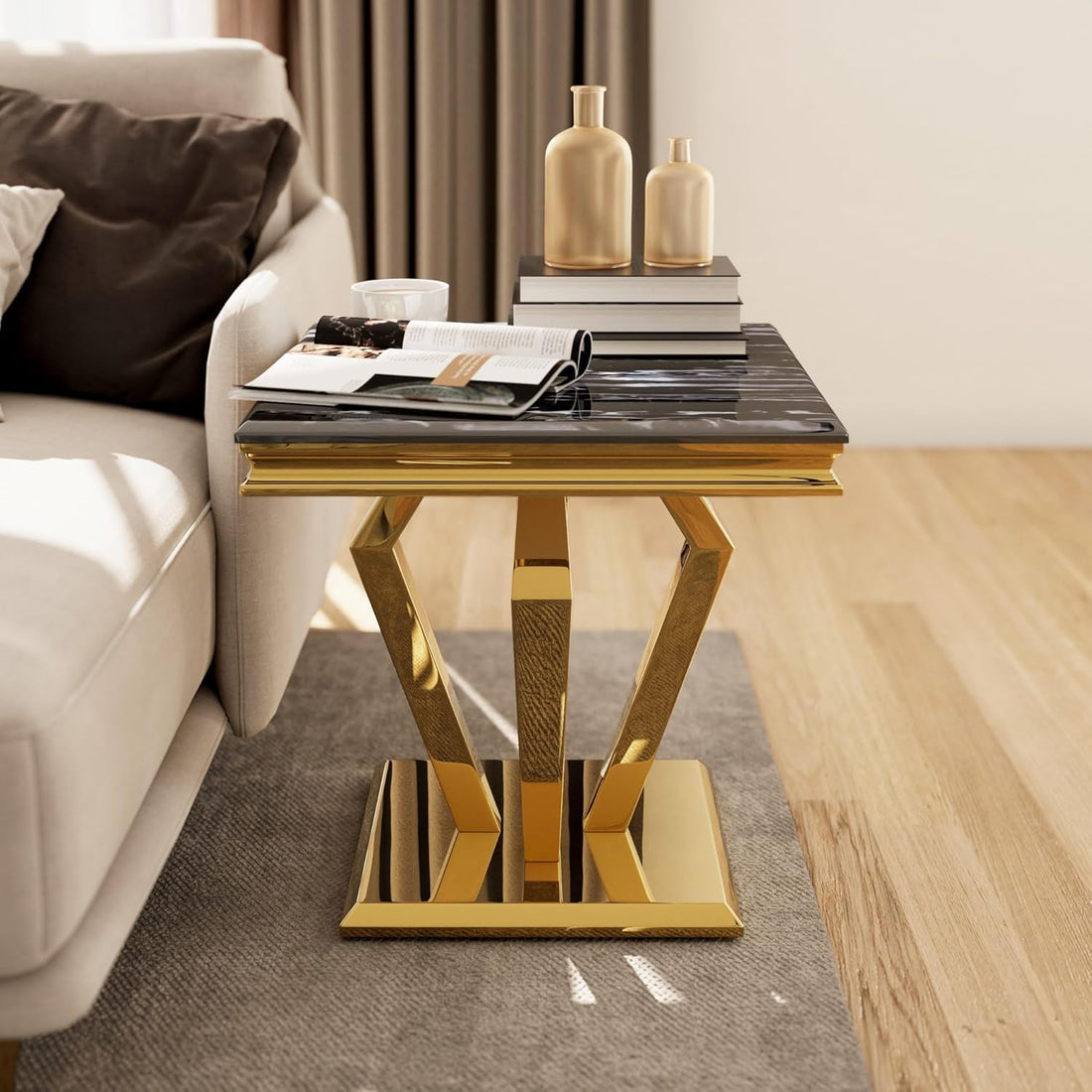 Modern side table with gold base and black marble top in a living room setting.