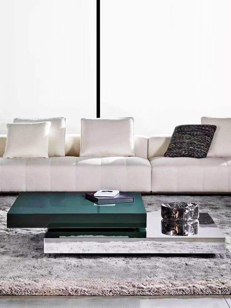 Modern living room with a white sofa, green coffee table, and decorative items.