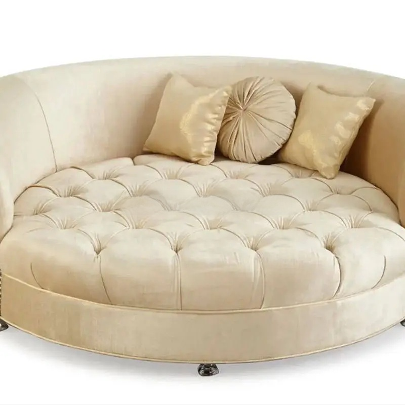 Beige round sofa with tufted cushion and decorative pillows on a white background