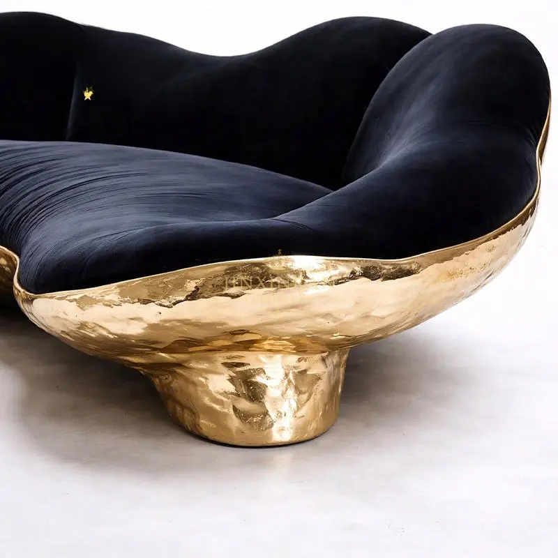 Modern chair with black cushion and gold base on a white background
