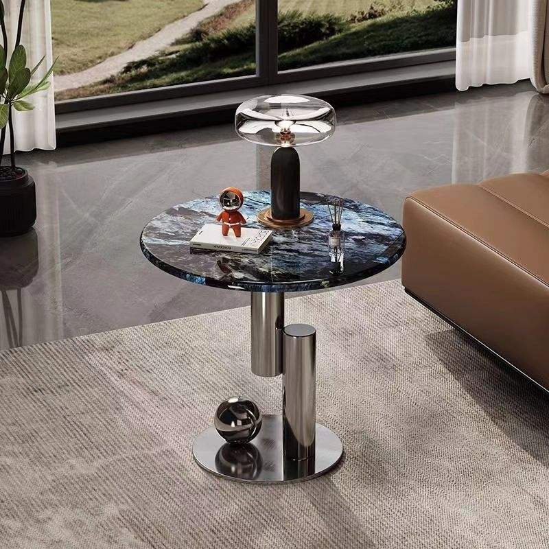 Round marble coffee table with metallic base in a modern living room setting