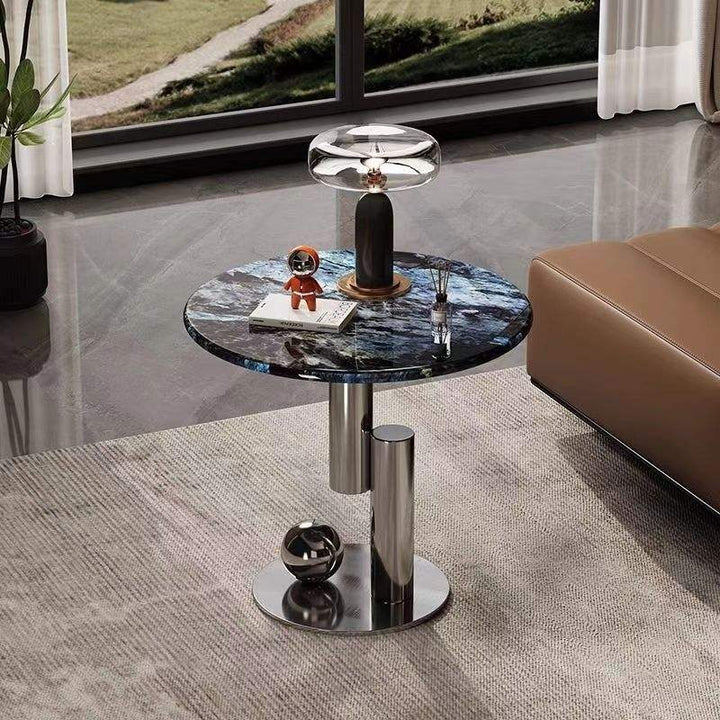 Round marble coffee table with metallic base in a modern living room setting