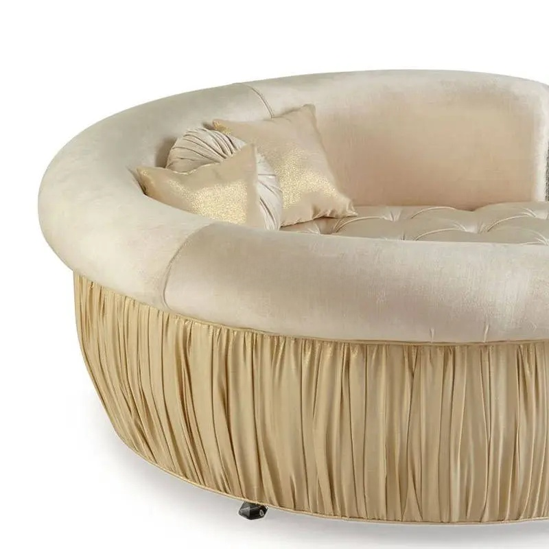 Beige round sofa with pleated skirt and decorative pillows on a white background