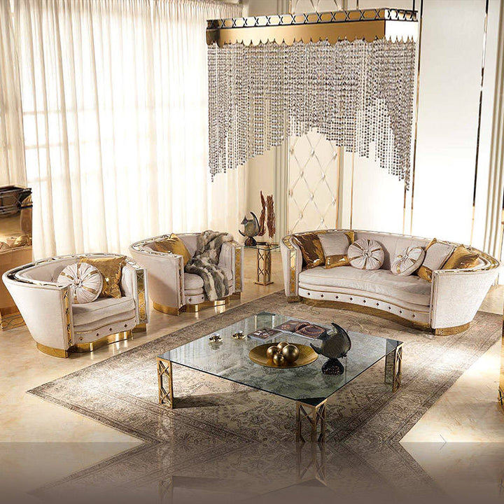Luxurious living room with white sofas, gold accents, and a decorative chandelier.