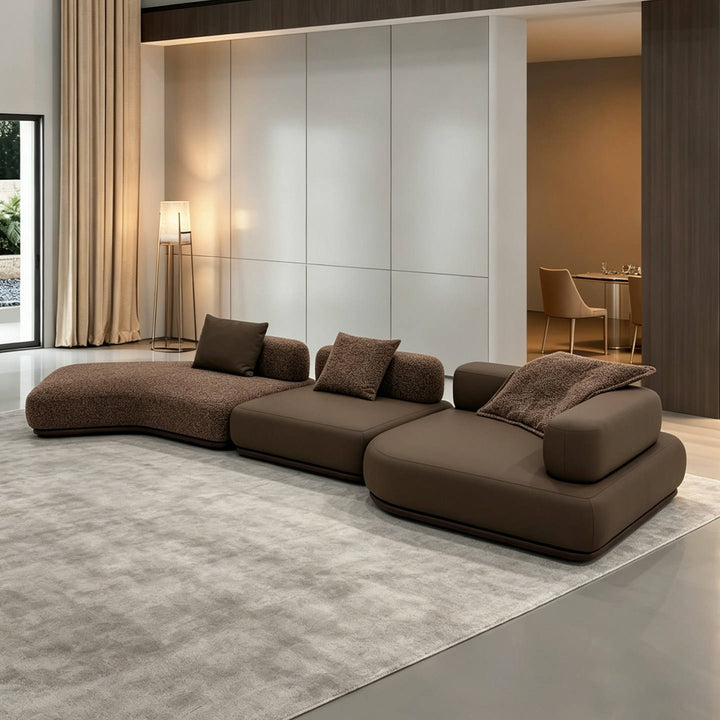 Modern brown sectional sofa in a living room setting with neutral decor.
