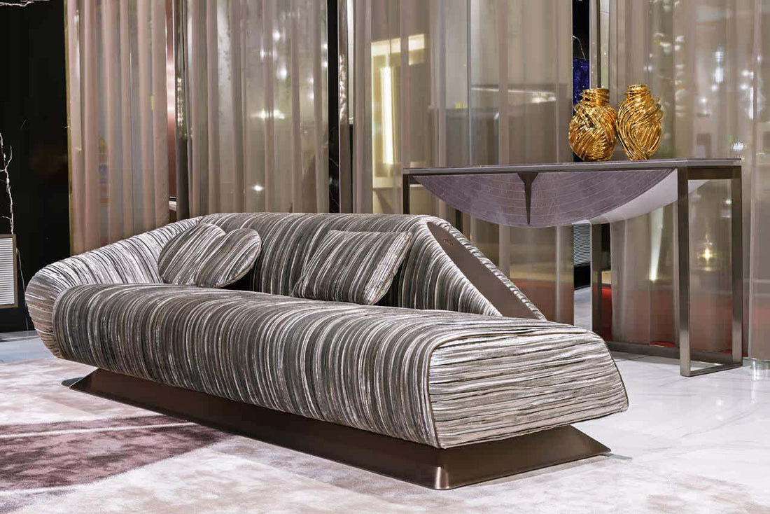 Modern gray striped sofa in a stylish room with a table and decorative items.