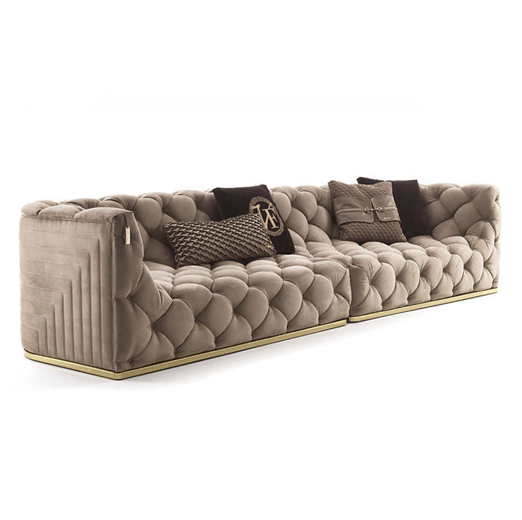 Beige tufted sofa with decorative pillows on a white background