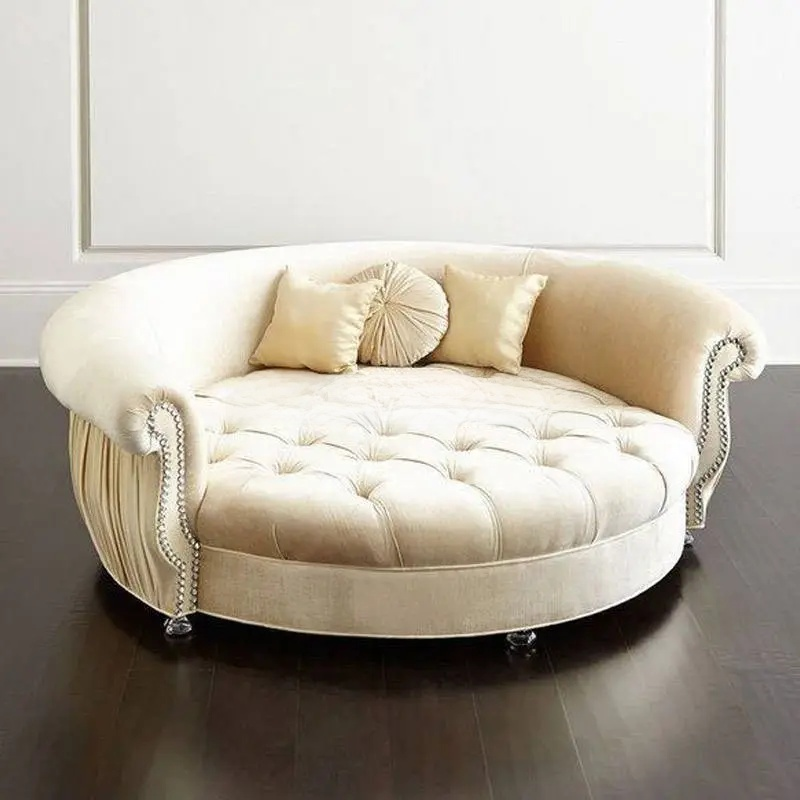 Beige tufted sofa with decorative pillows on a dark wooden floor.