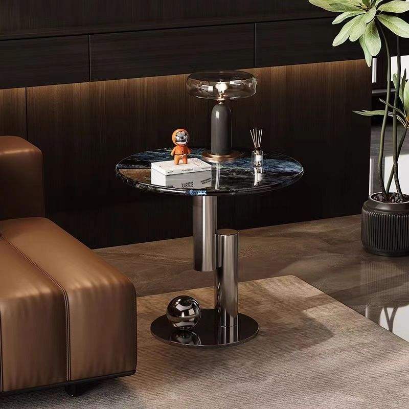 Modern living room with a round side table, brown sofa, and decorative items.