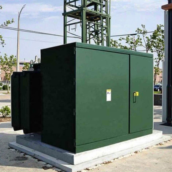 Green electrical transformer on a concrete base with a clear sky background