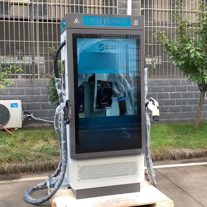 Electric vehicle charging station with a screen displaying charging information, outdoors.