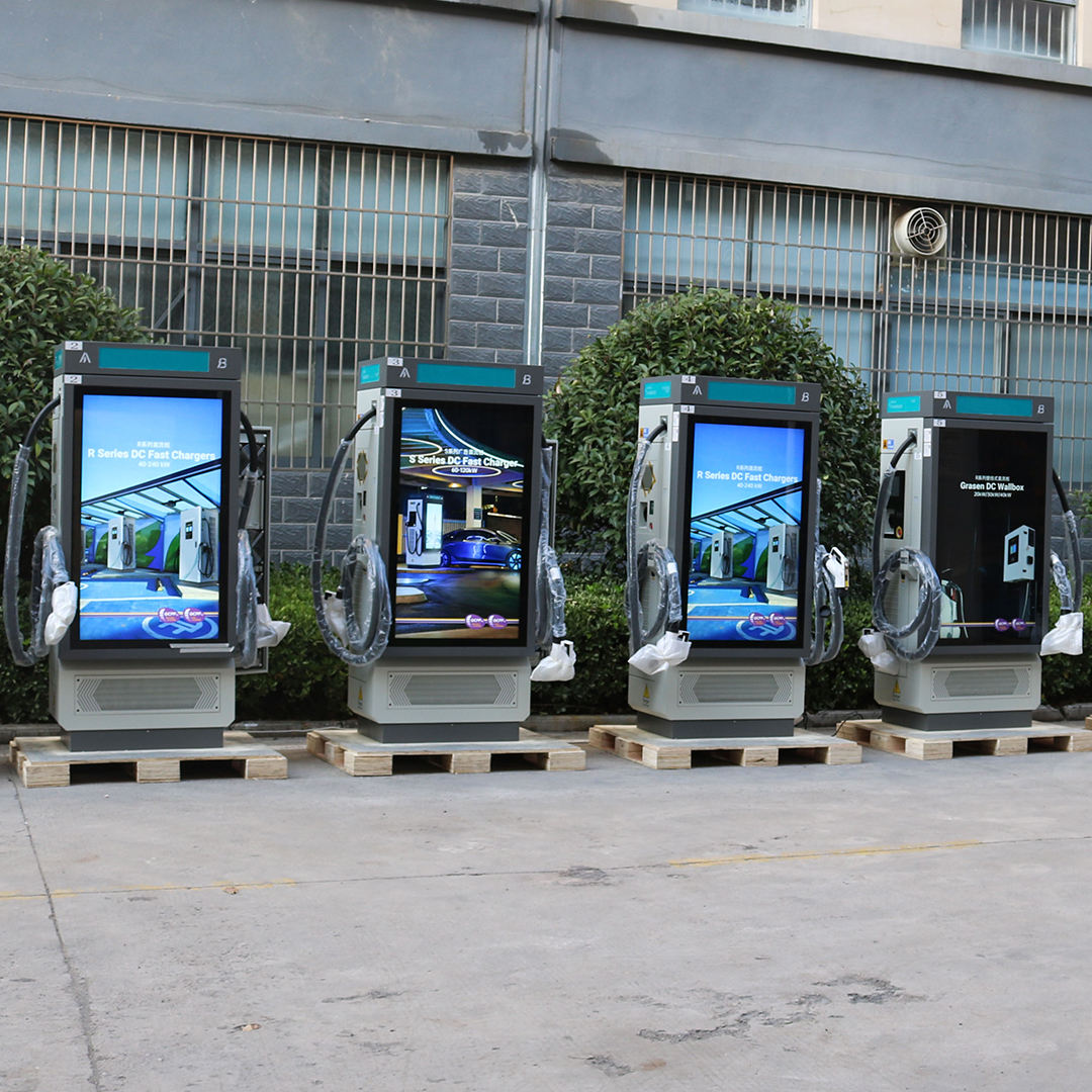 Four digital display stands with screens outdoors on a concrete surface.