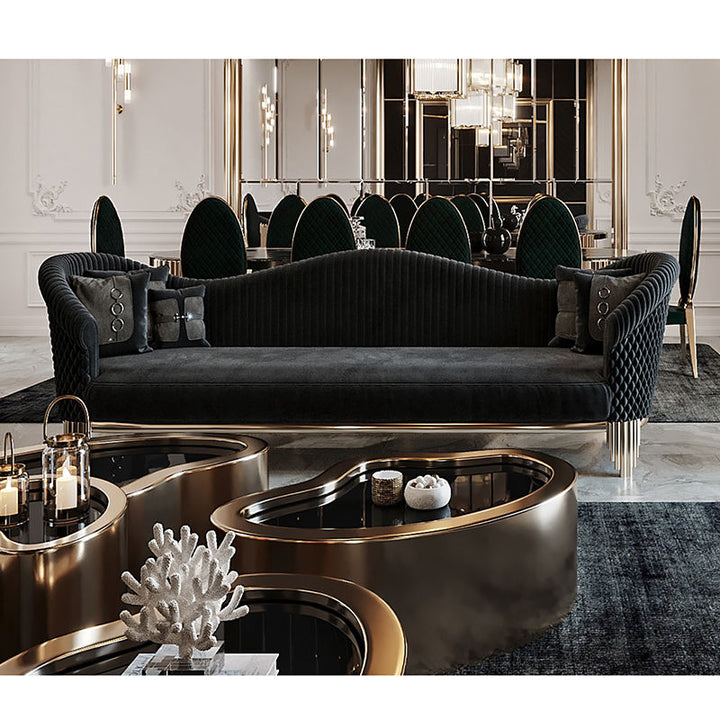 Modern living room with a black sofa, decorative tables, and a mirror.