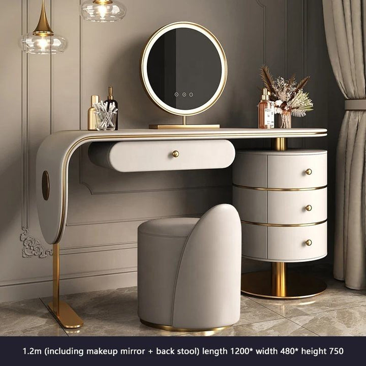 Modern vanity table with round mirror and stool in a stylish room.