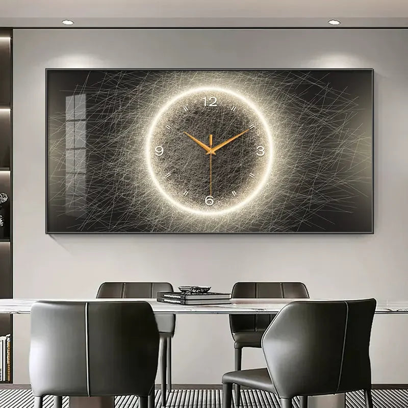 A large rectangular wall clock with a glowing circular design and gold hands, mounted above a dining table with dark chairs in a modern room.