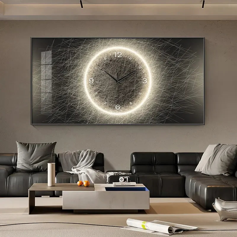 A large rectangular wall art piece hanging above a black leather sofa in a modern living room. The artwork shows a glowing circular clock face with a bright ring and fine sketch-like lines on a dark background.