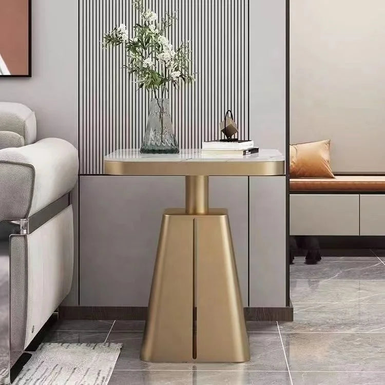 Modern interior with a gold side table and gray sofa.