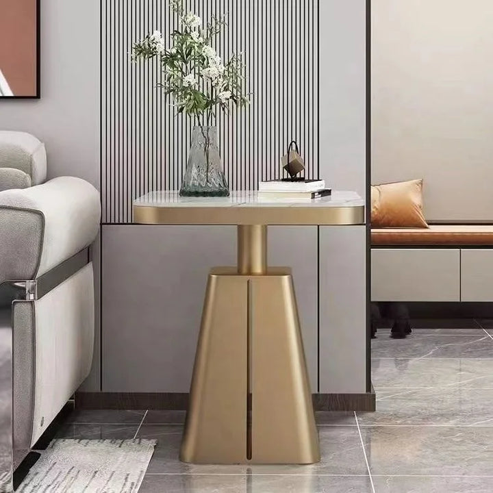 Modern interior with a gold side table and gray sofa.