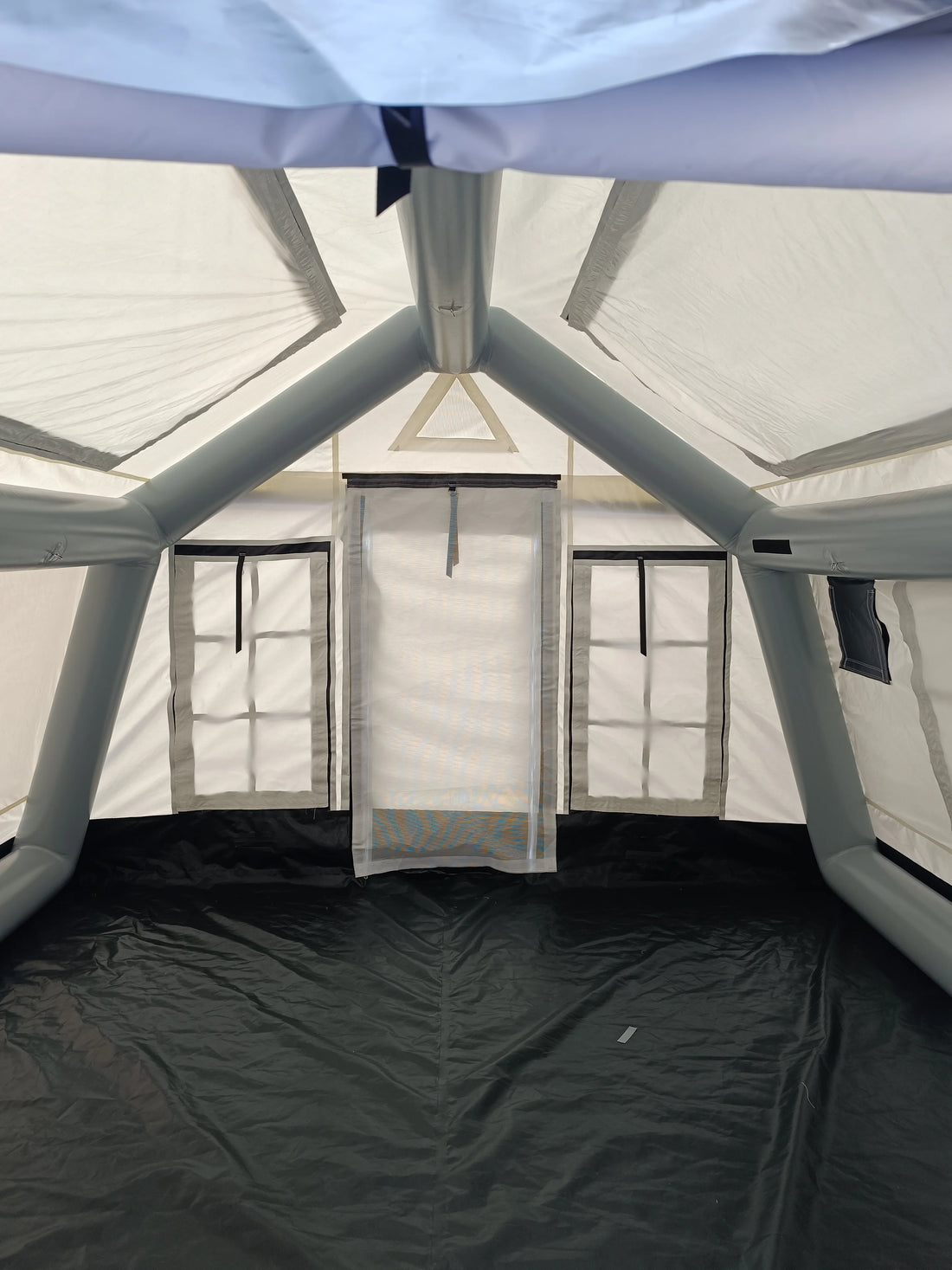 Inside view of a tent with mesh walls and black floor