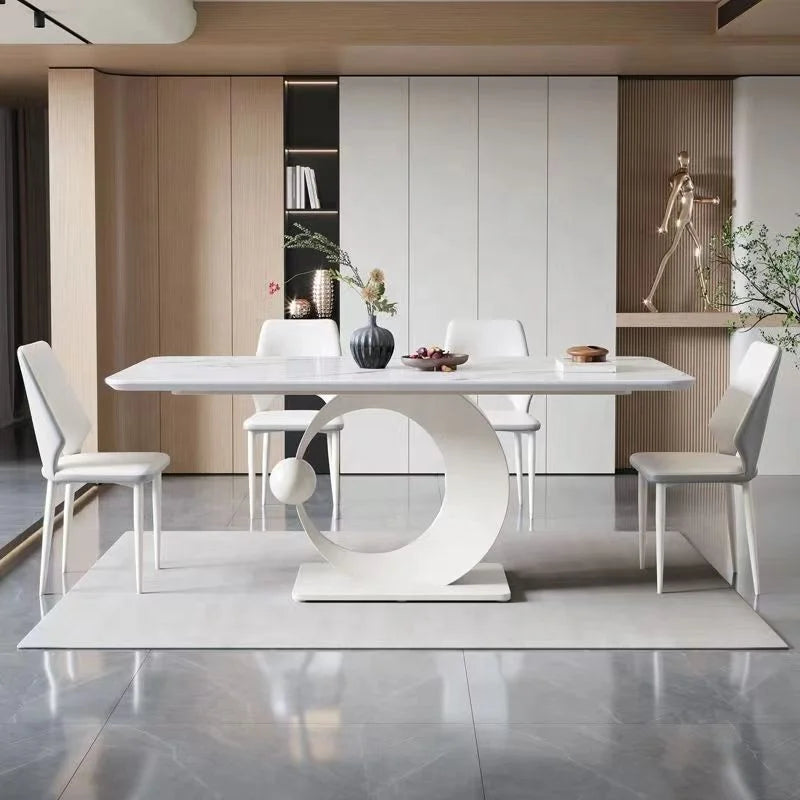 Modern dining room with a white oval table and chairs.