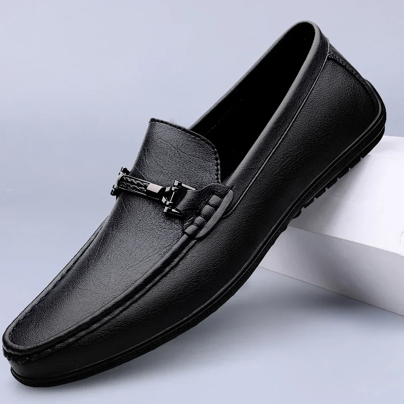 Black leather loafer shoe on a light gray background
