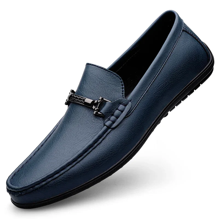 Blue loafer shoe with a metal buckle on a white background