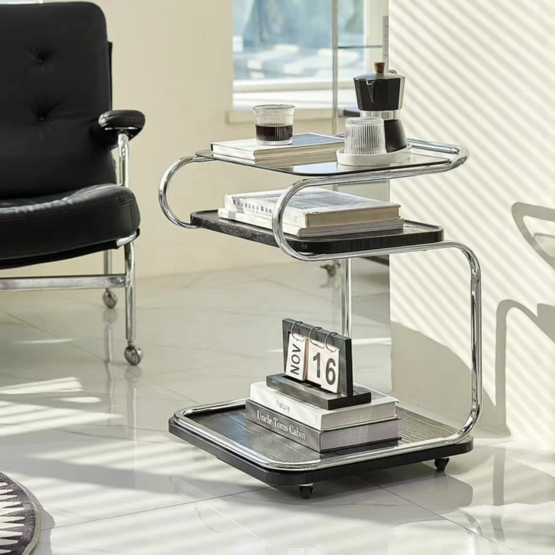 Modern side table with books and a calendar in a room with a chair and mirror.