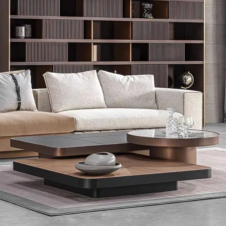 Modern living room with a gray sofa, glass coffee table, and bookshelf.