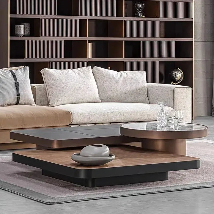 Modern living room with a gray sofa, glass coffee table, and bookshelf.